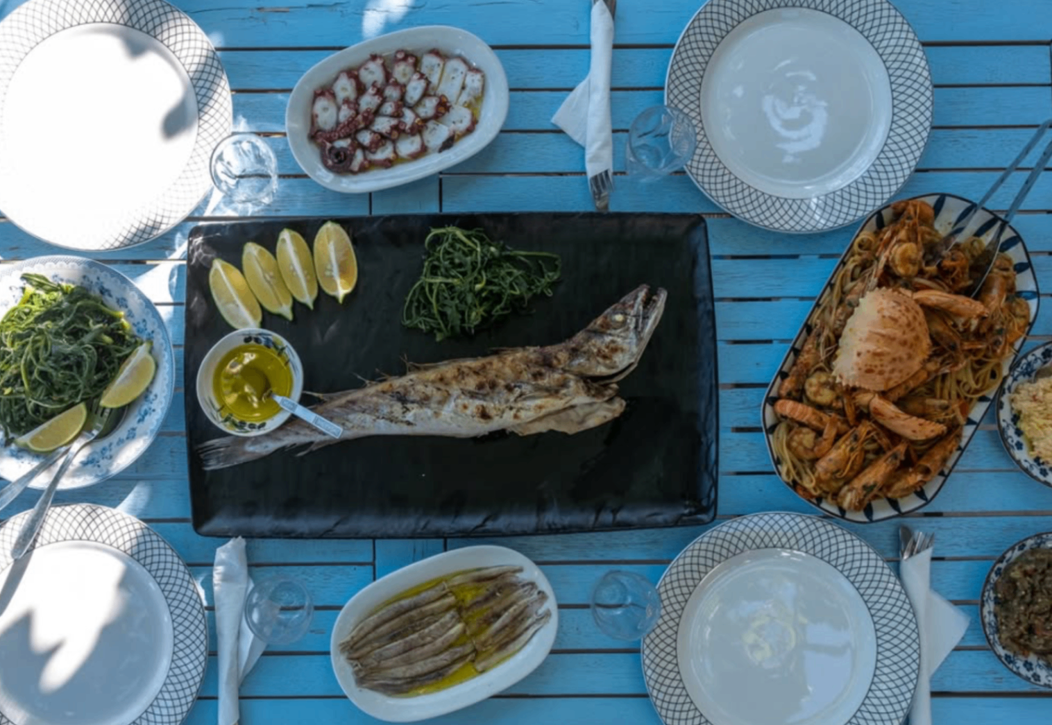 Seafood table in Tolo with grilled fish and pasta